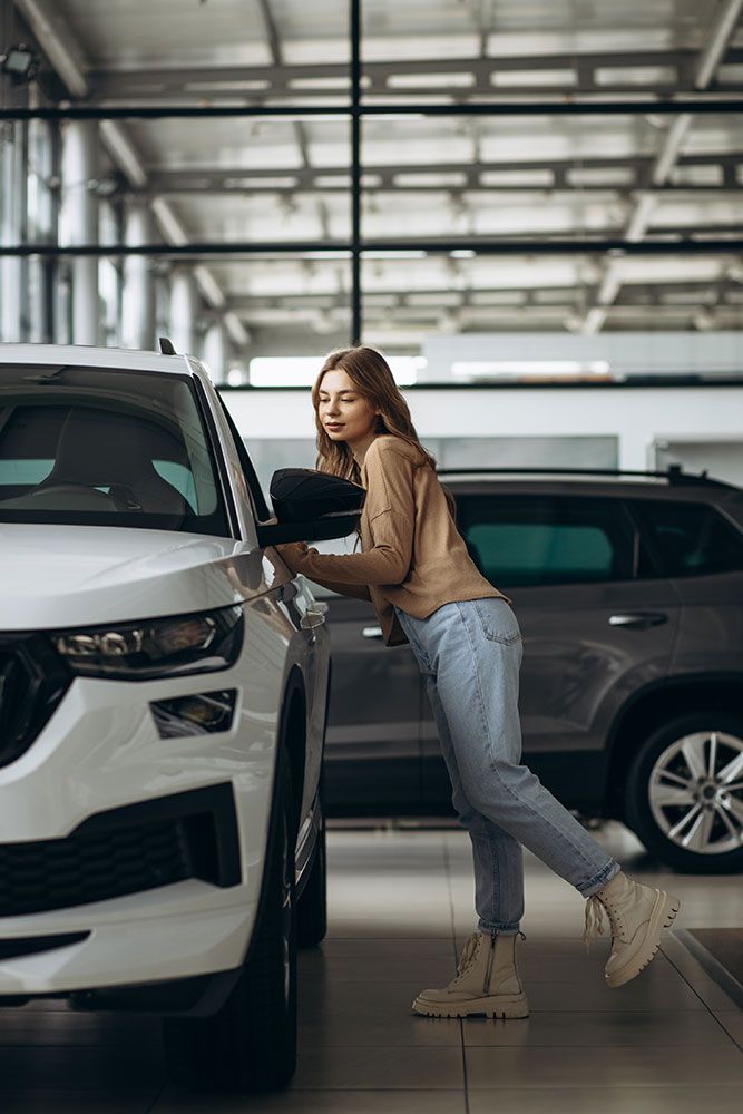 Frau, die ein Auto im Autohaus auswählt